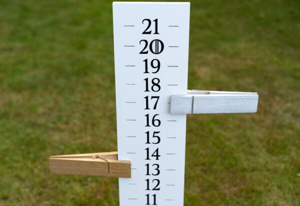 close up view of cornhole score keeper with oversized clothespins marking point totals